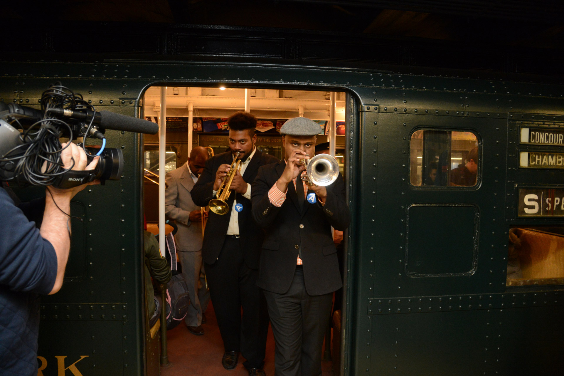 Film camera filming musicians leave subway car