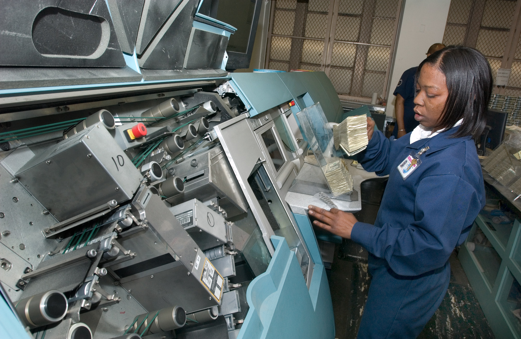 An employee sorts and wraps money in the Money Room, Photograph by Patrick Cashin, 2006