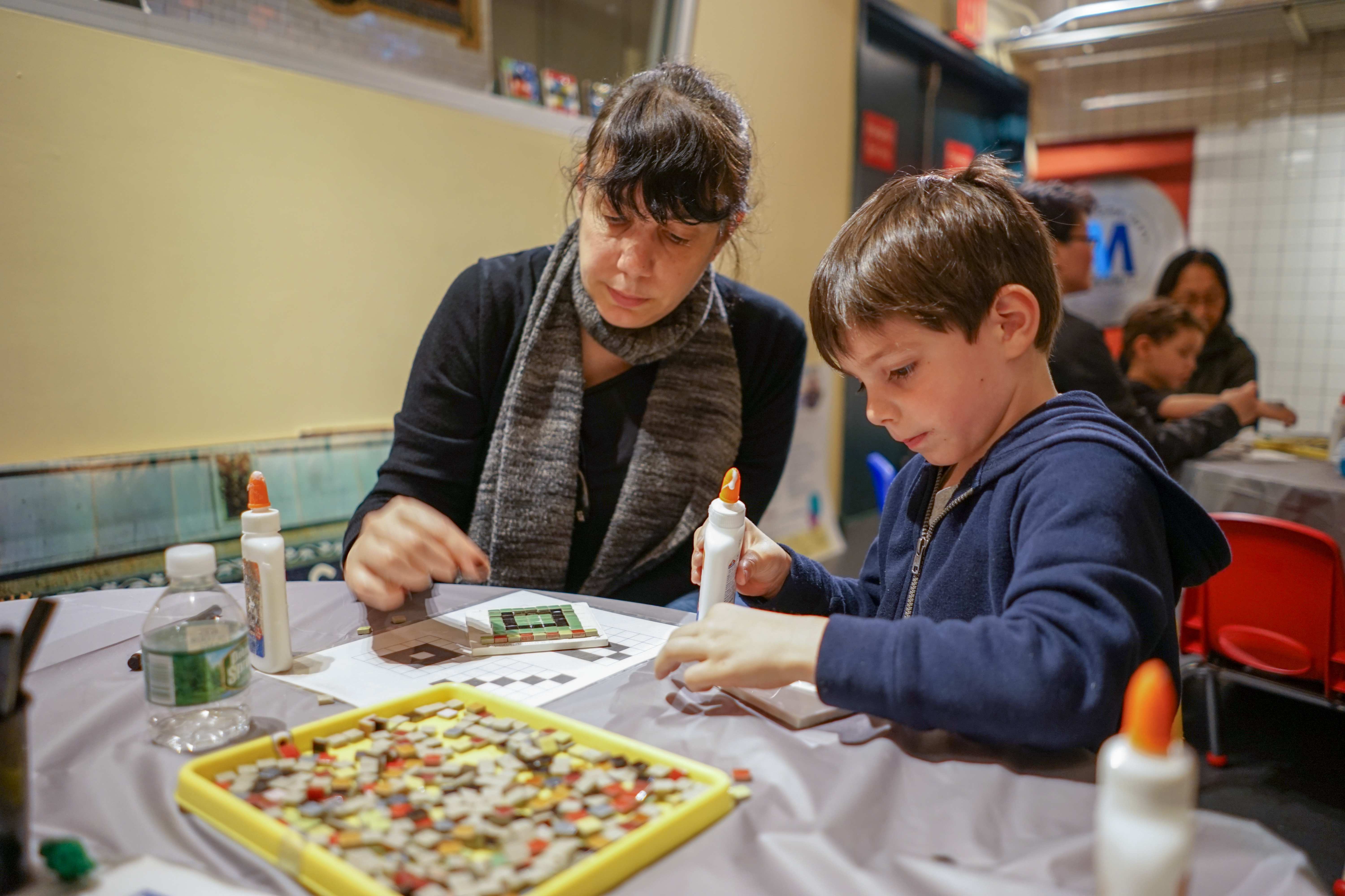 A parent and child engaged in a craft activity.