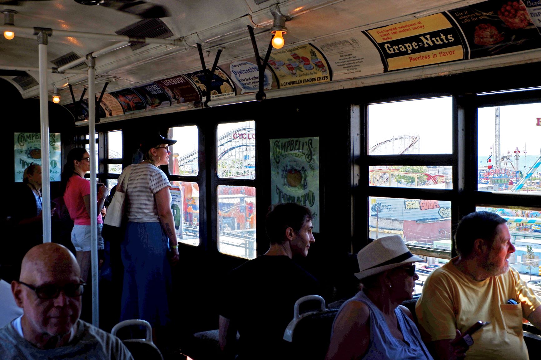 People on vintage train with Coney Island in background