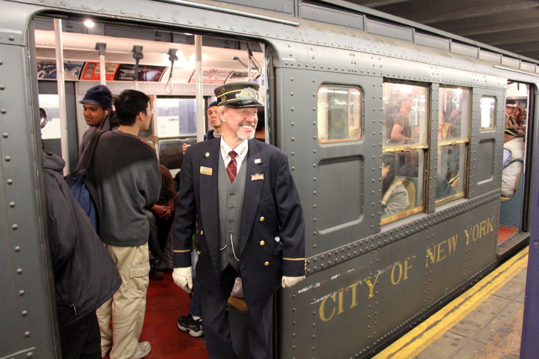 Conductor in vintage outfit in front of vintage R1-9 cars