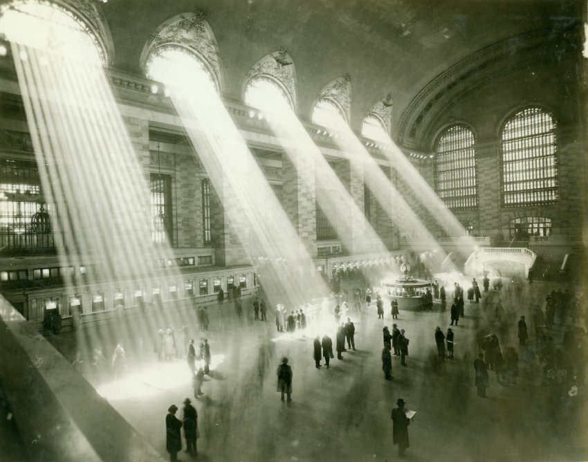 black and white photo of five beams of light shining into Grand Central's main hall