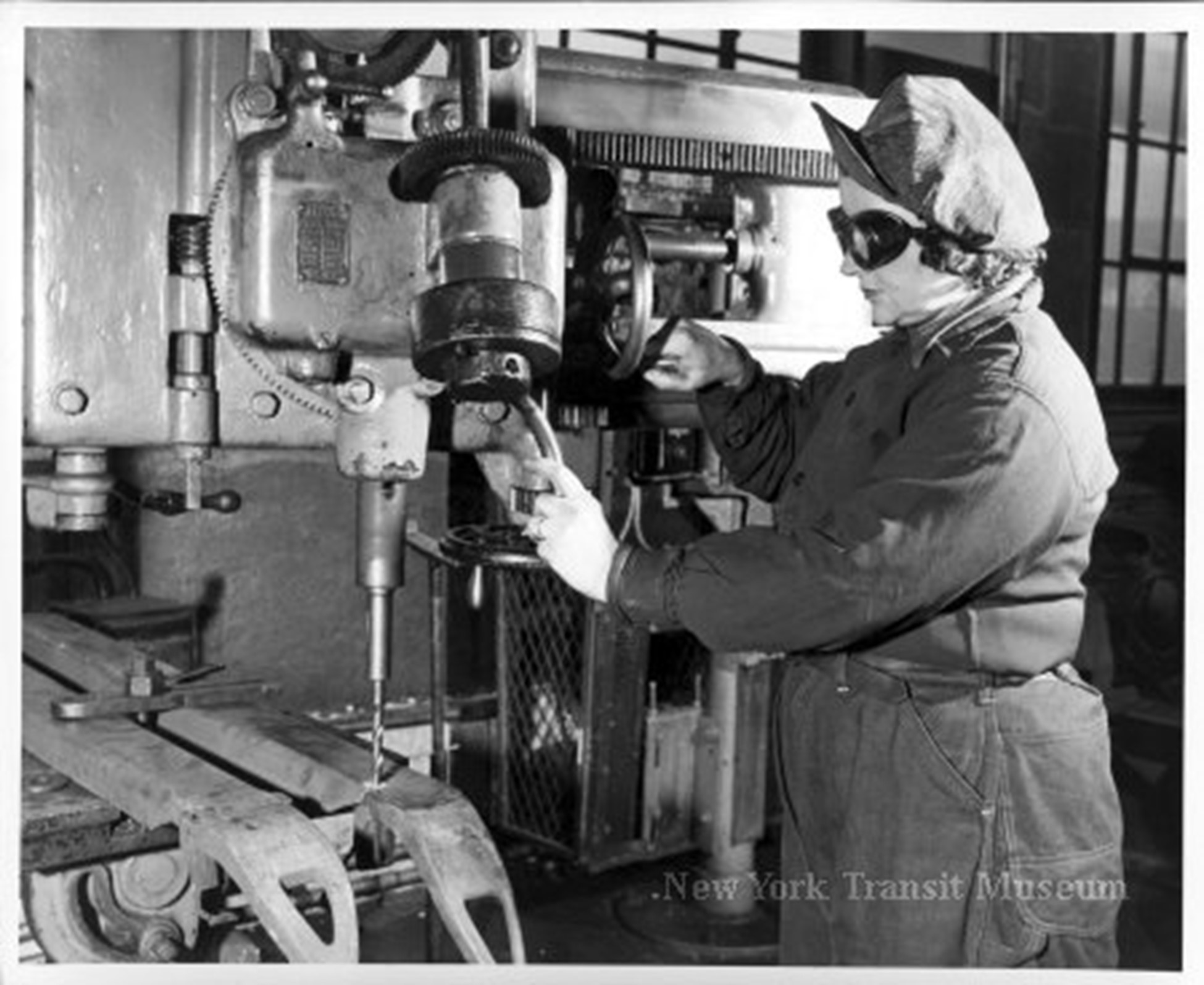 Woman employee operating a drilling machine in a PRR shop