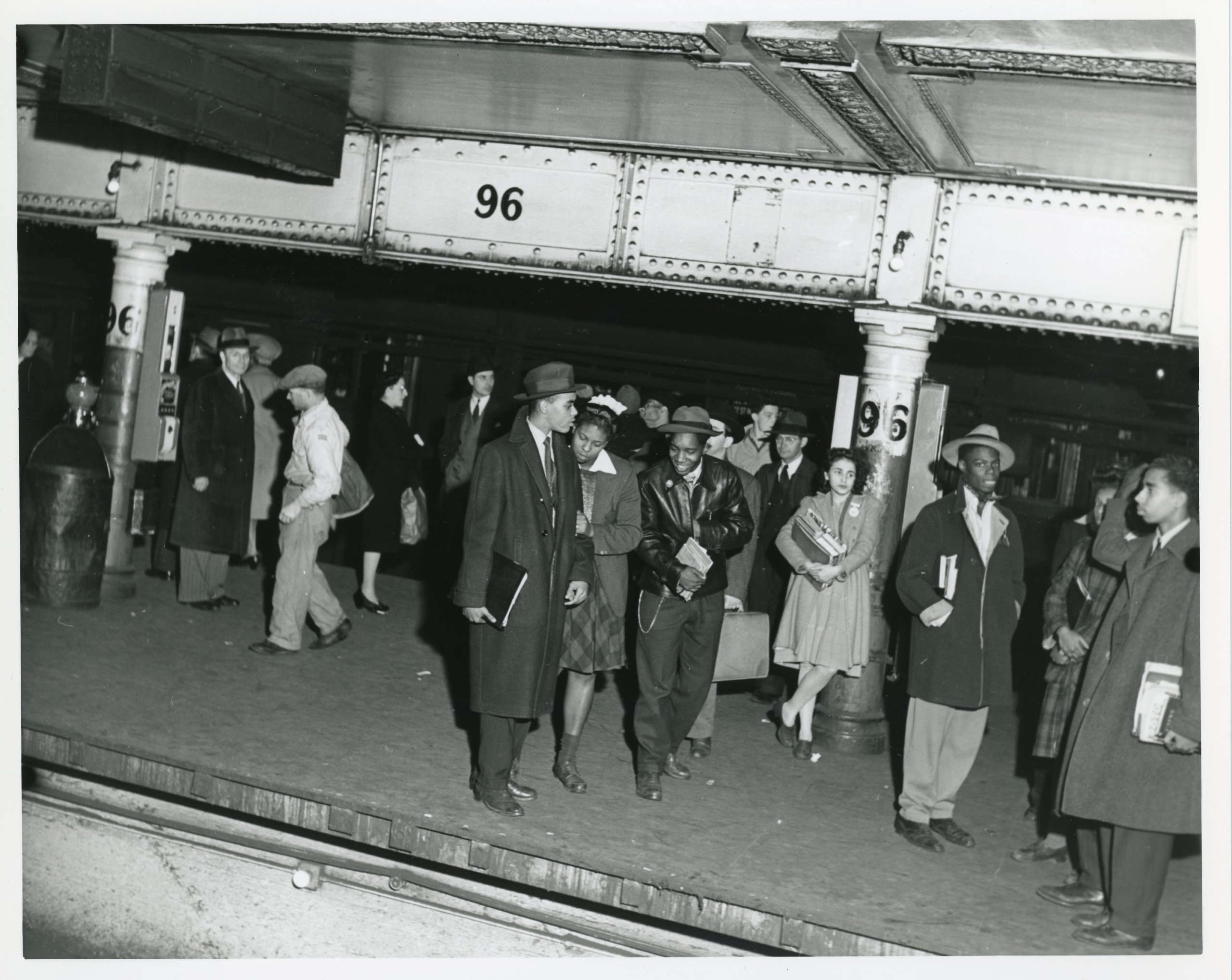Young men and women stand on the subway platform at 96th street.