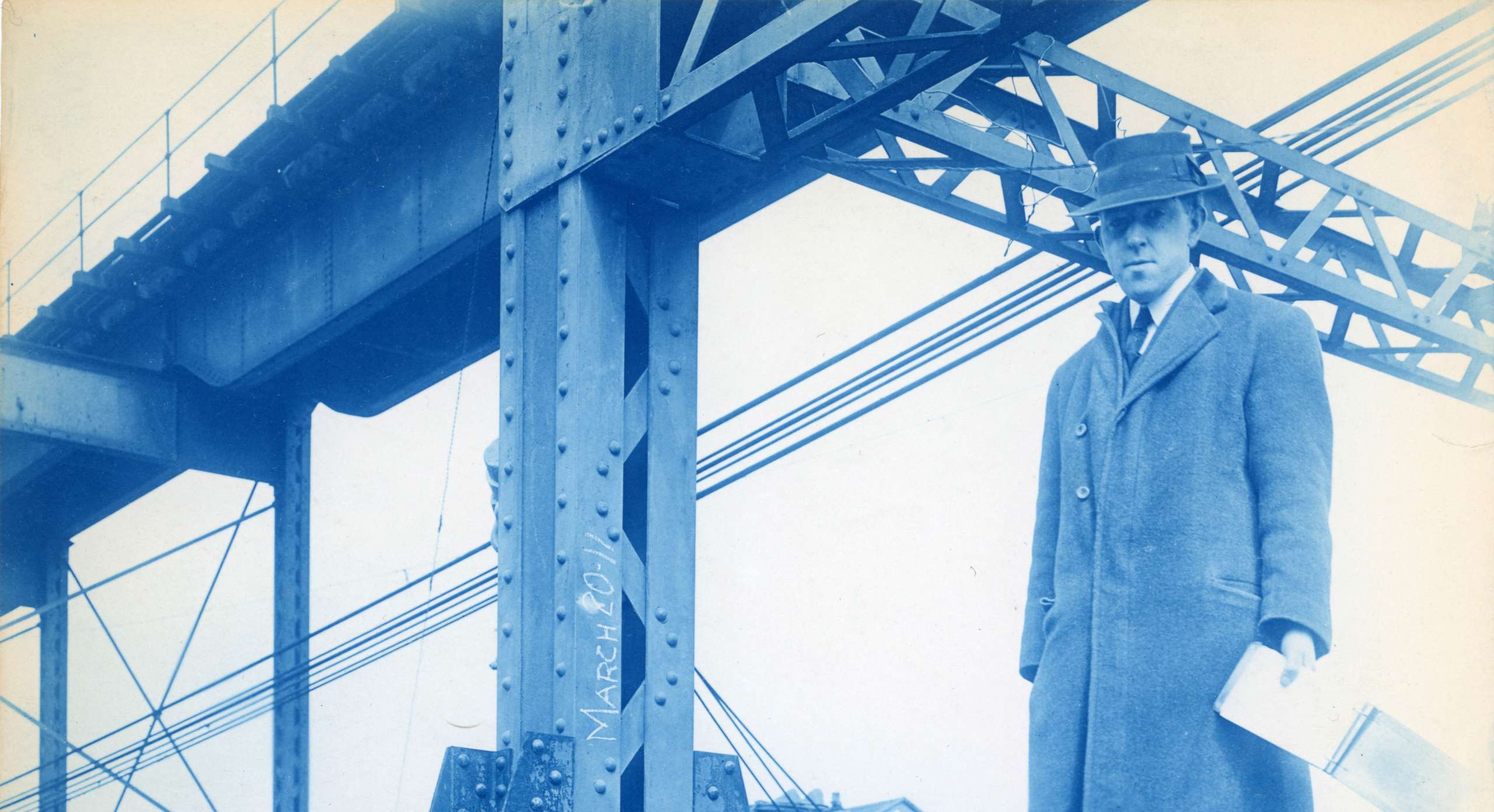 Man in suit with survey notebook stands on construction beam