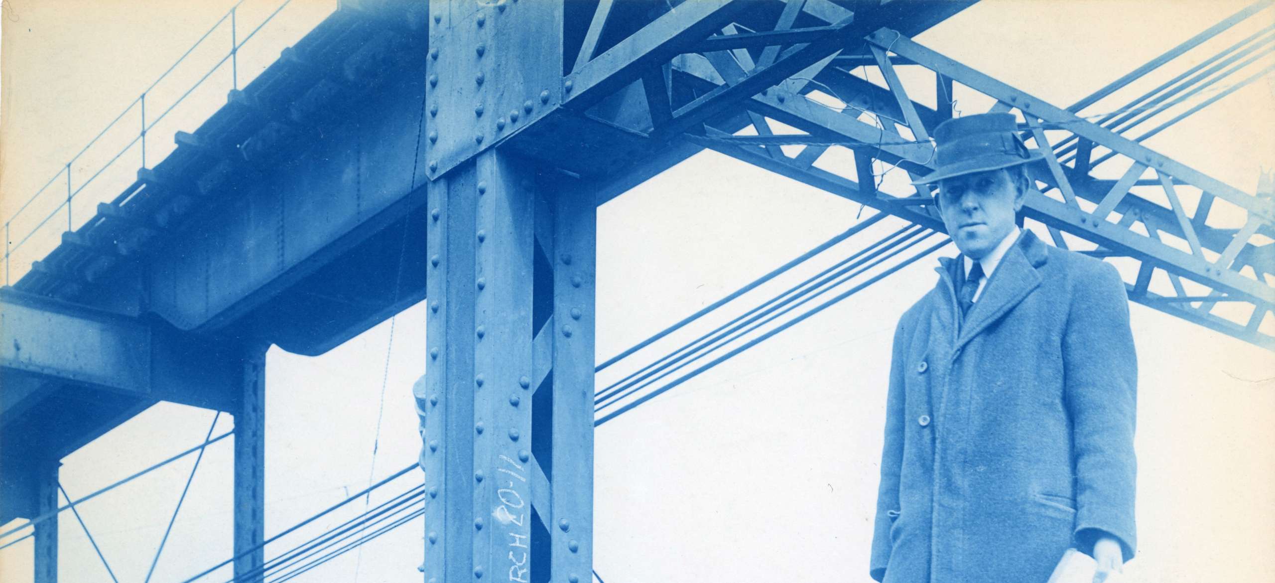 Man in suit with survey notebook stands on construction beam