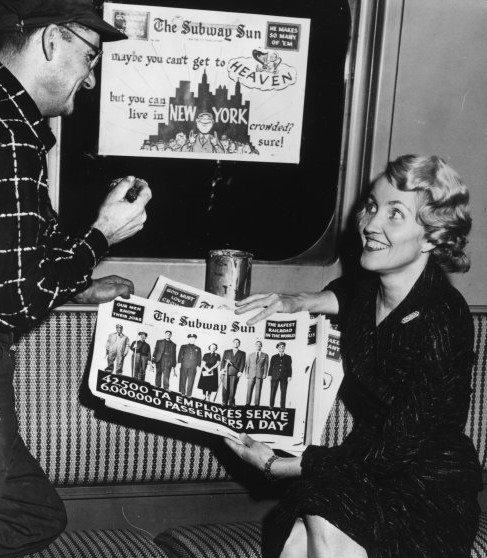 Man talking to woman holding Subway Sun advertisement