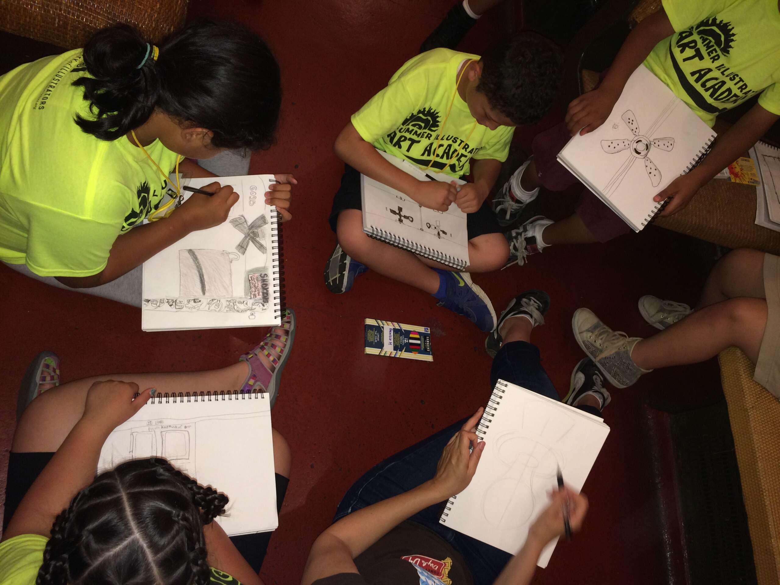 Young campers sitting in a vintage train car drawing various parts of the train.