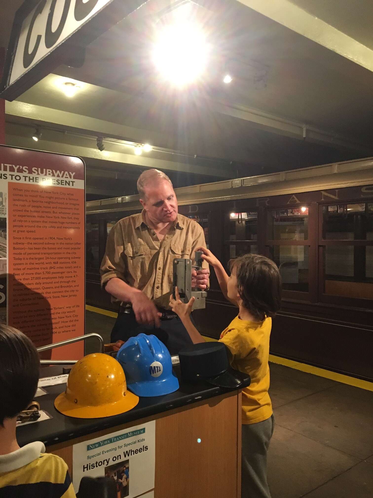 A museum educator shows a child transit objects at the History on Wheels cart.