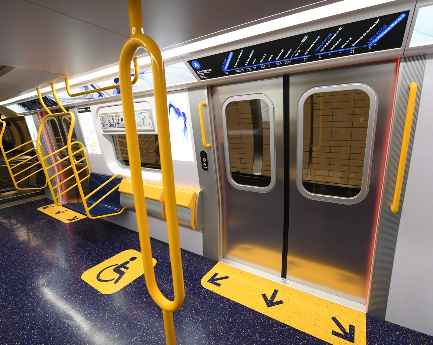 Interior of R211 train with handicap sign and other accessibility features