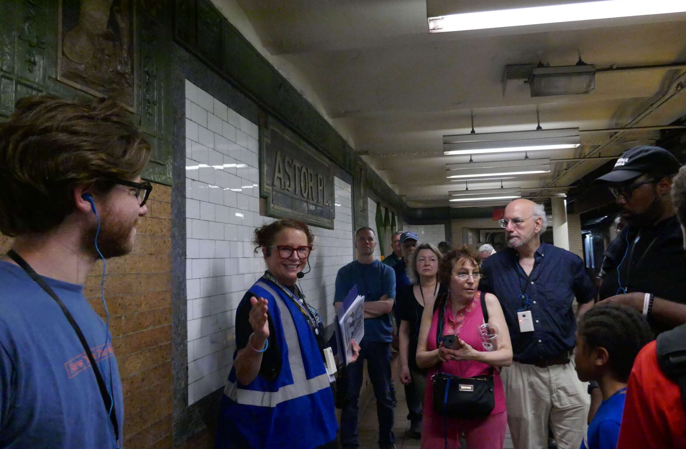 Tour guide speaks to attendees on train platform