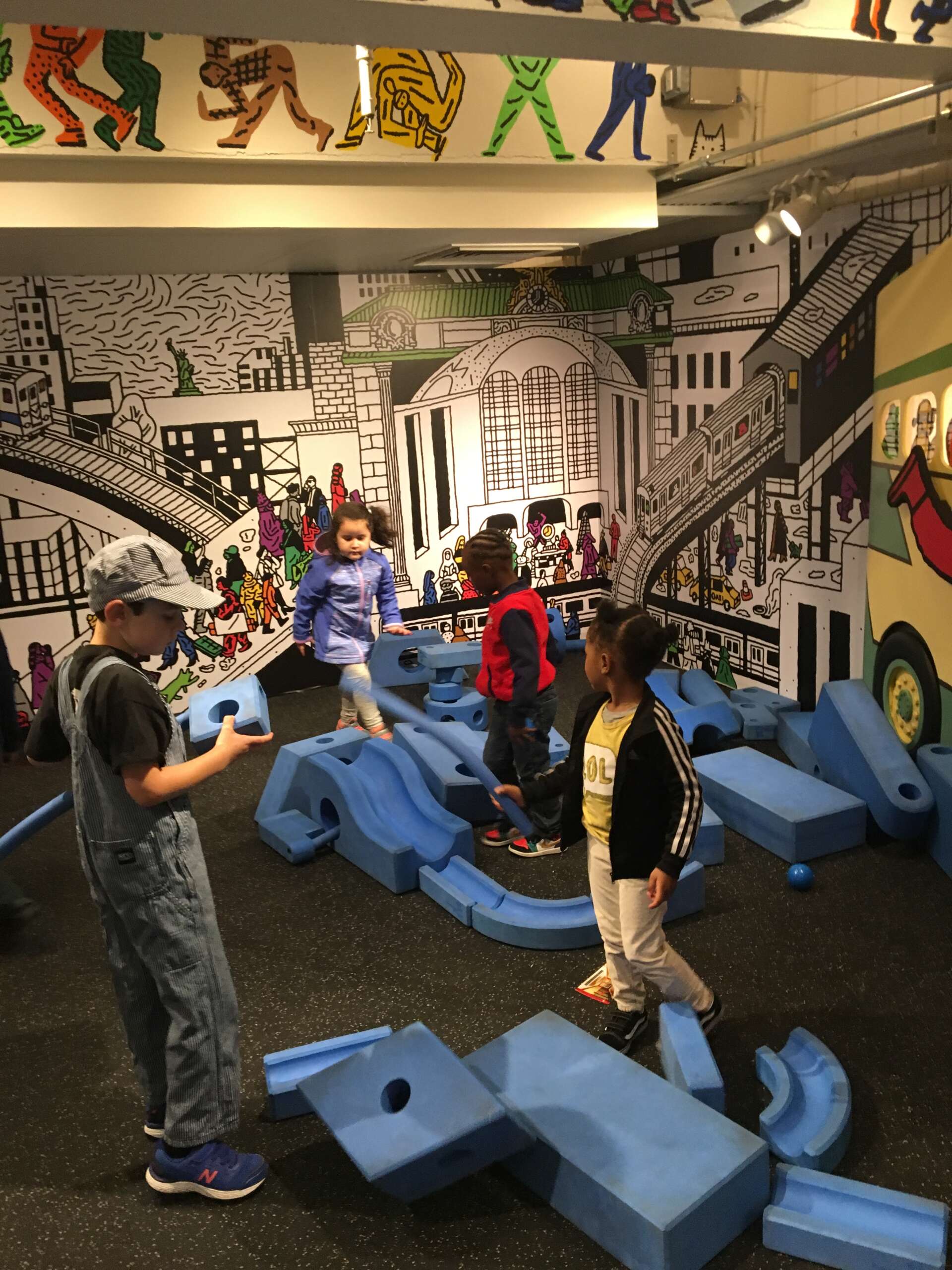 Children play with blue foam blocks in the museum.
