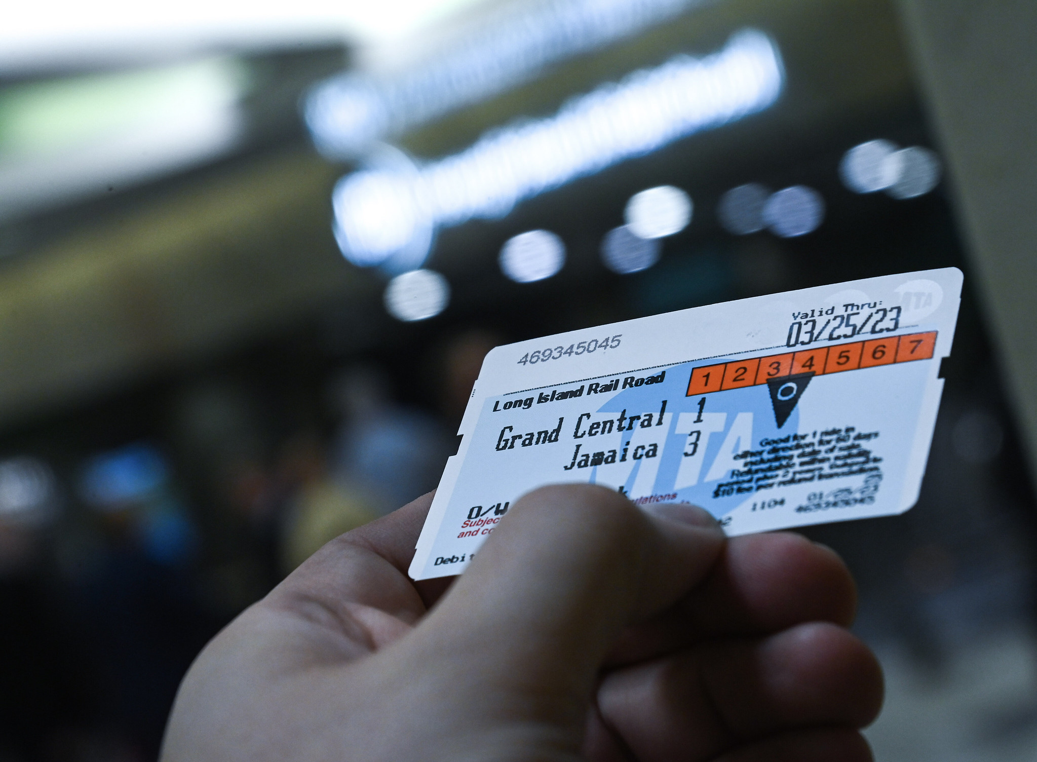 A hand holds a Long Island Rail Road ticket