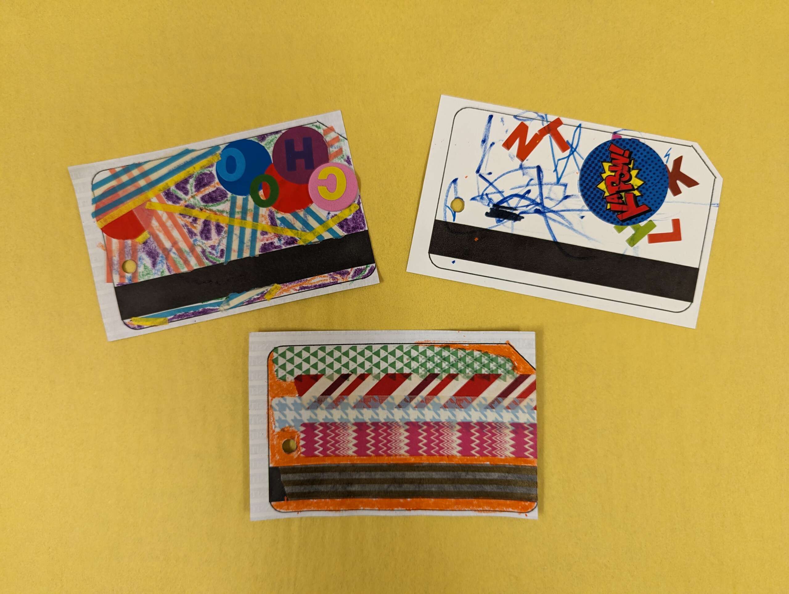 Three examples of MetroCards made from a mix of crayon, marker, stickers, and colored tape.