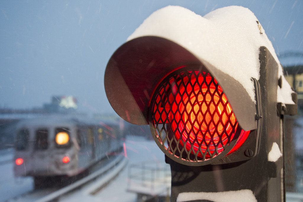 Close up of nyc subway signal with train in the background