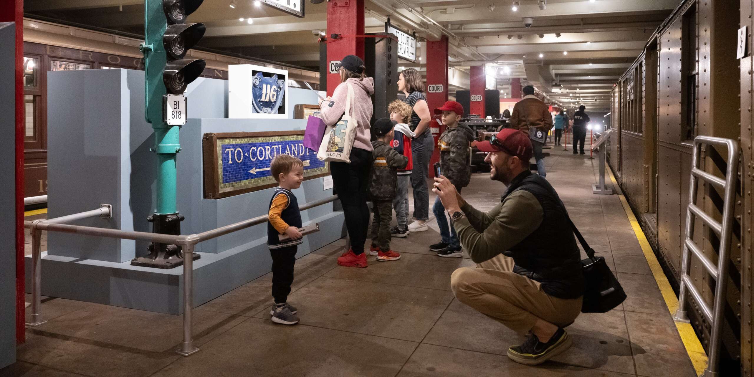 Parent taking photo of child on Transit Museum Platform