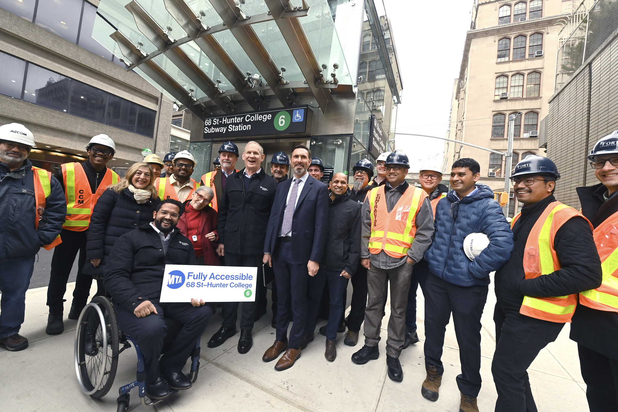 MTA leaders and construction workers pose in front of new station elevator.