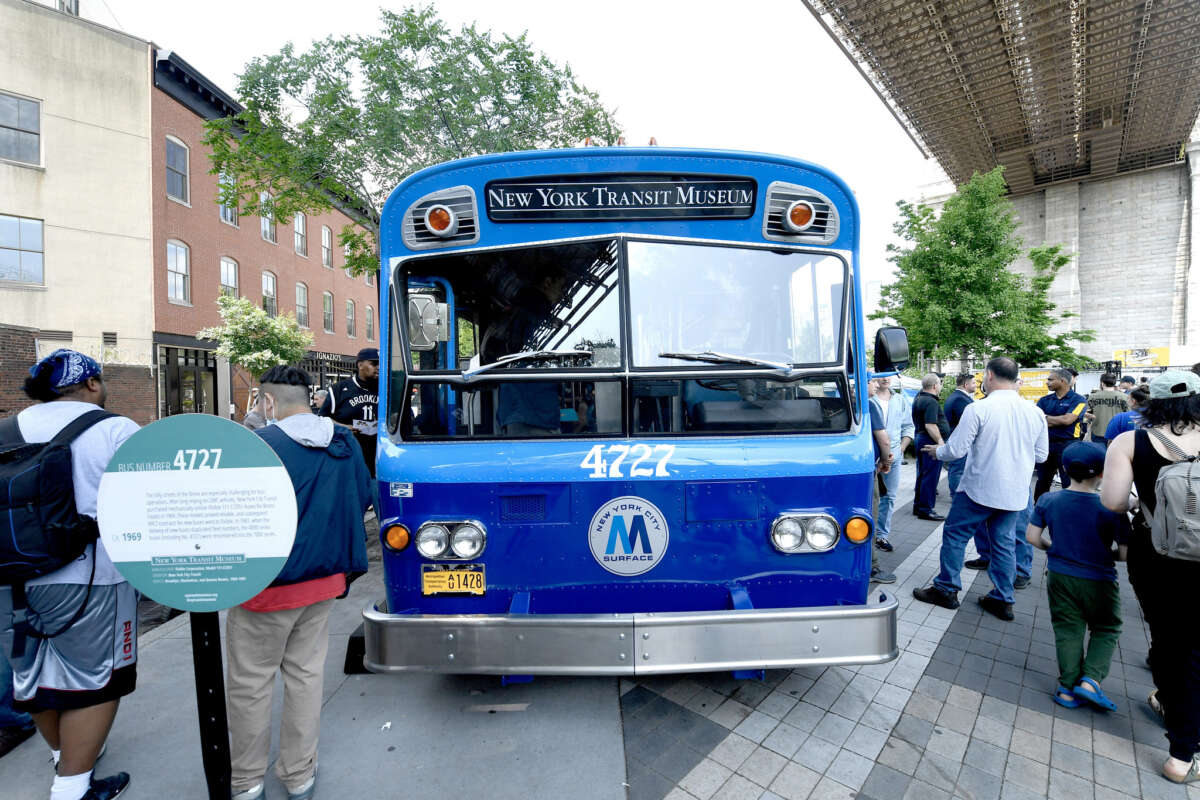 Blue bus under the Brooklyn Bridge