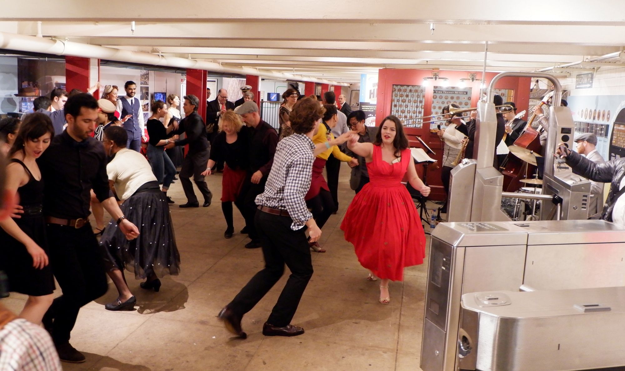 People dance in museum mezzanine to live musicians.