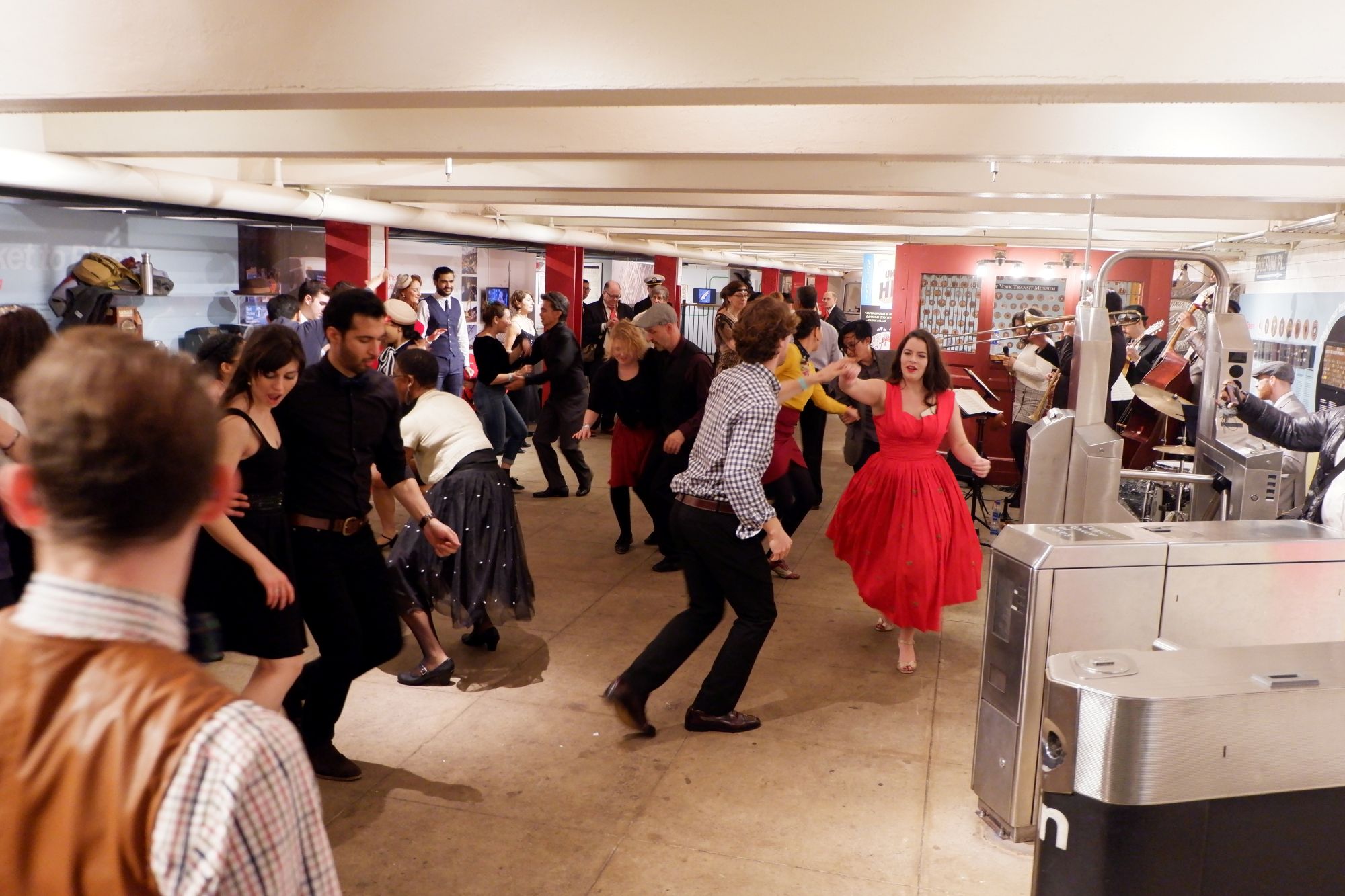 People dance in museum mezzanine to live musicians.