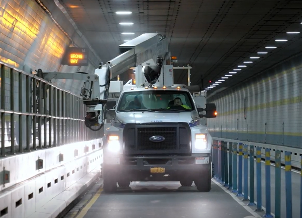 A truck scrubbing a tunnel with big brushes.