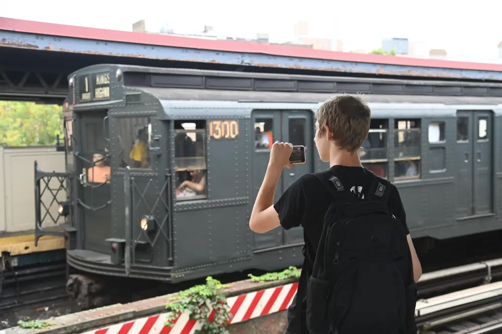 Railfan capturing the R6 #1300 Car on their cell phone
