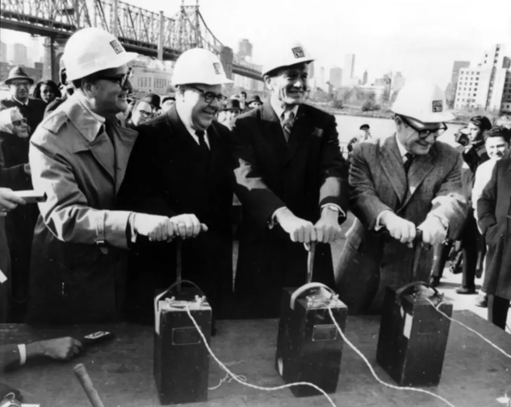 Men posing for photo with their hands on explosives detonators for the tunnel groundbreaking ceremony