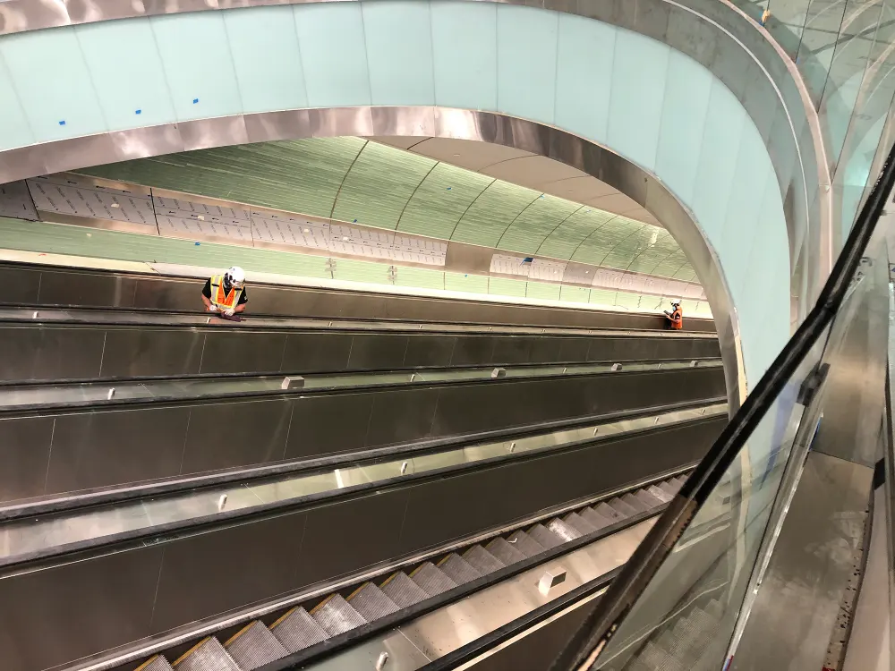 Man Cleaning escalator wellway