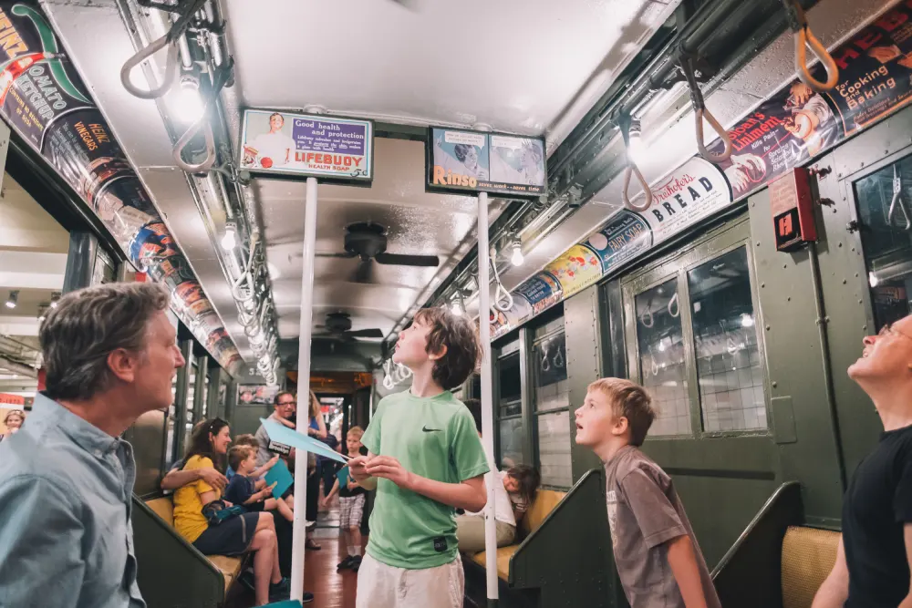 Children marvel at vintage train while parent watches