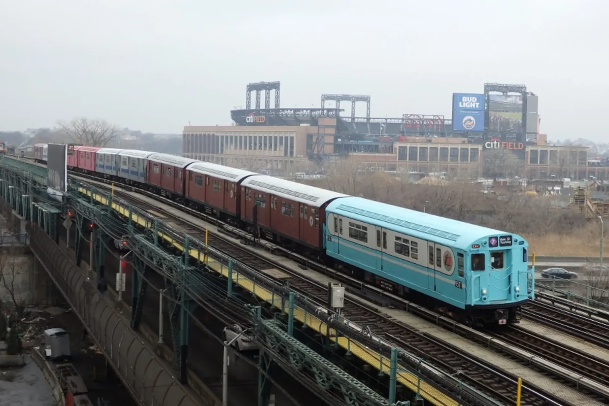 Multi colored train cars riding on elevated track