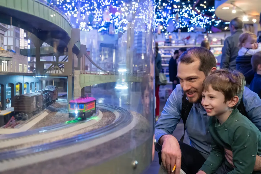 Man and child viewing model train exhibit