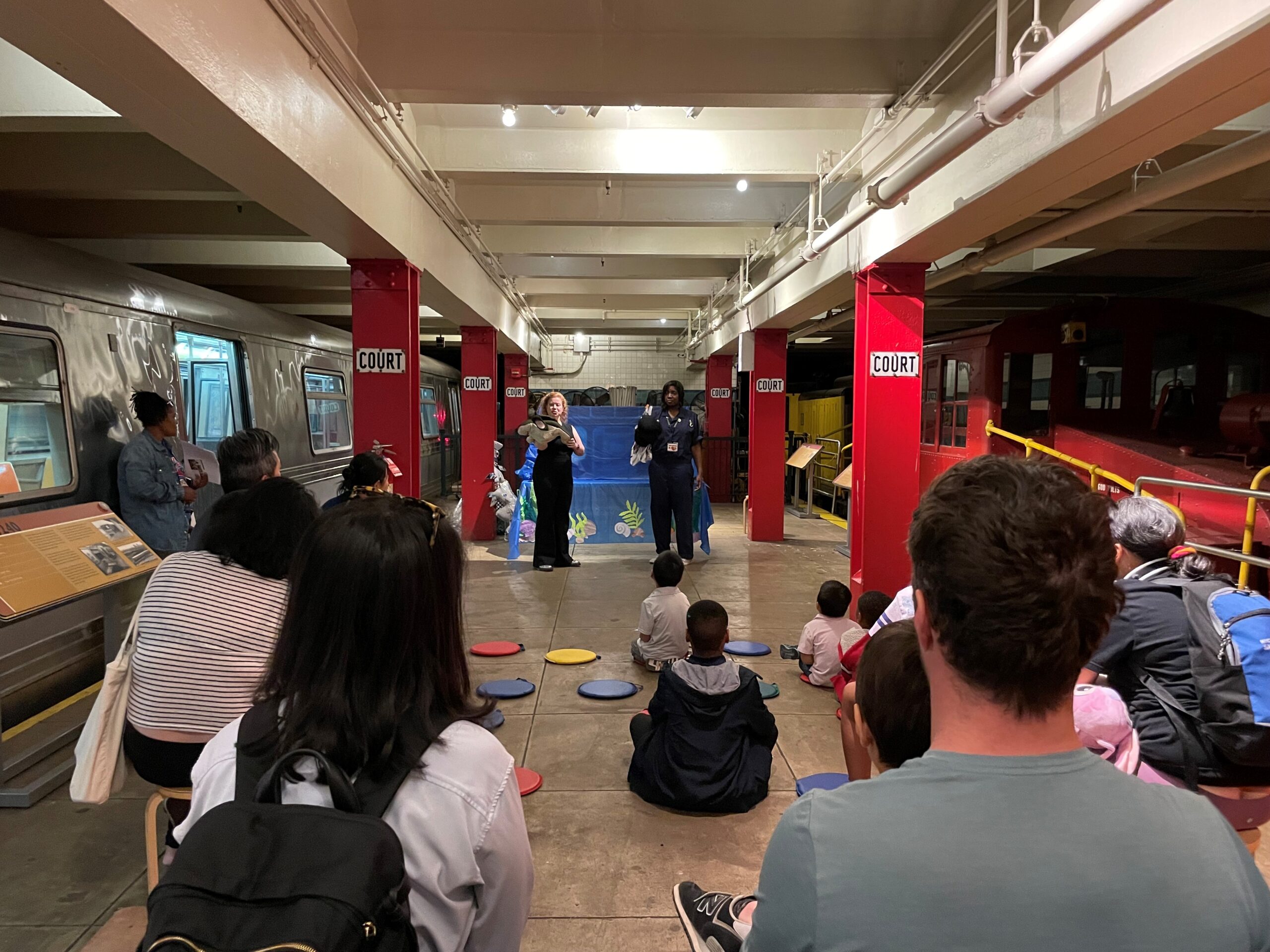 Families watch a puppet show on the Museum's subway platform.