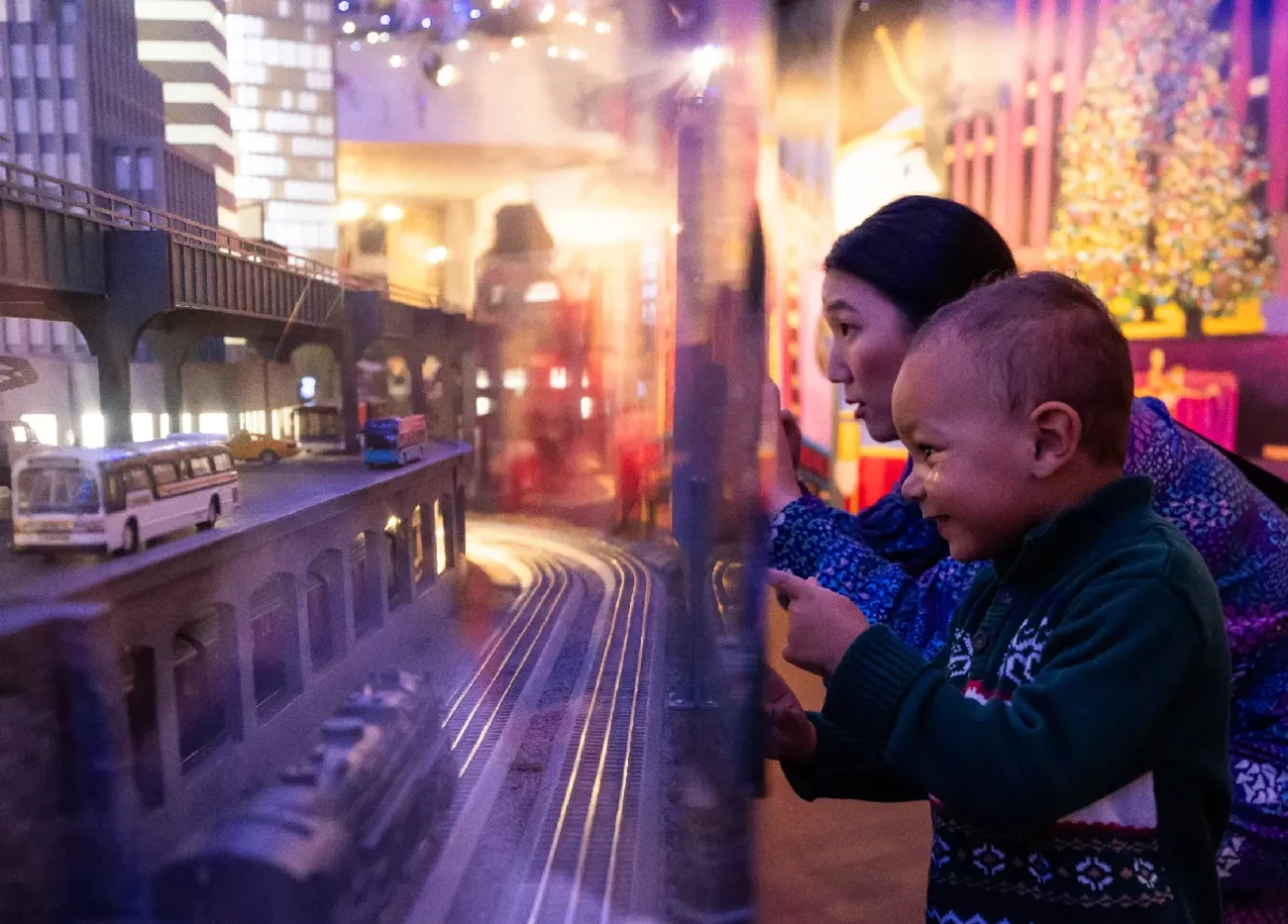 Woman and child look at model trains