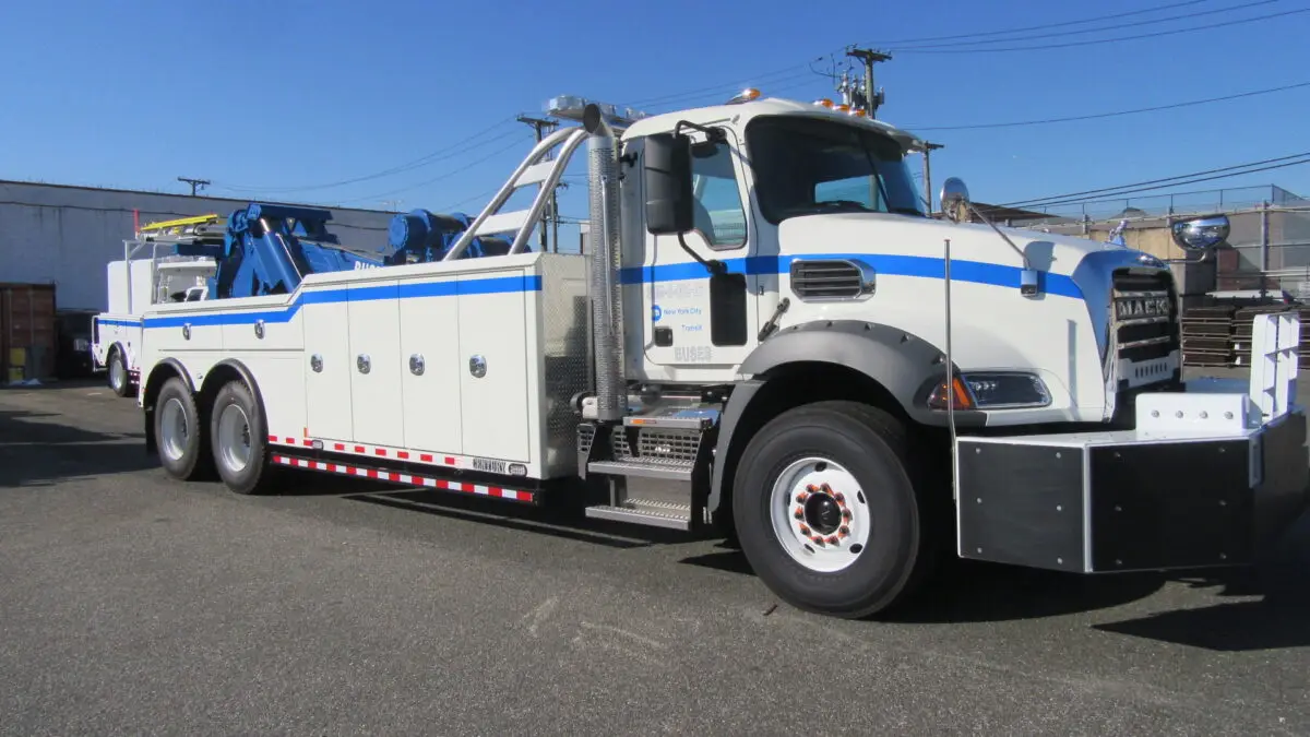 White bus tow truck with a large blue strip.