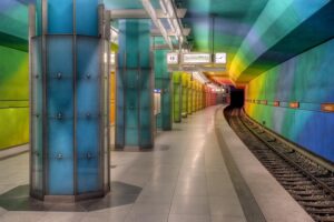 Interior subway station with rainbow colored walls and columns.