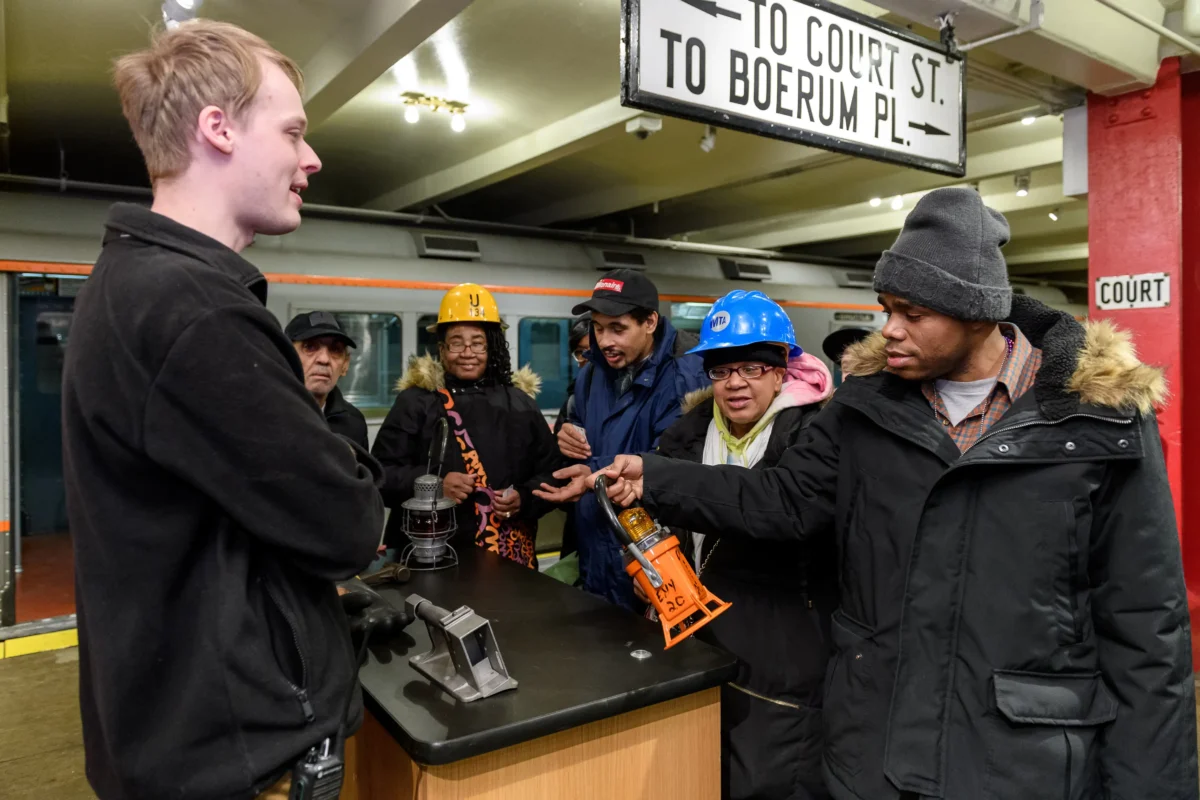 Museum staff showing Dab Hab Day participants objects at the history on wheels cart