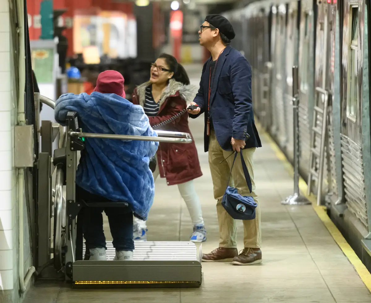 Visitor using the museum's wheel chair lift to get to the platform level
