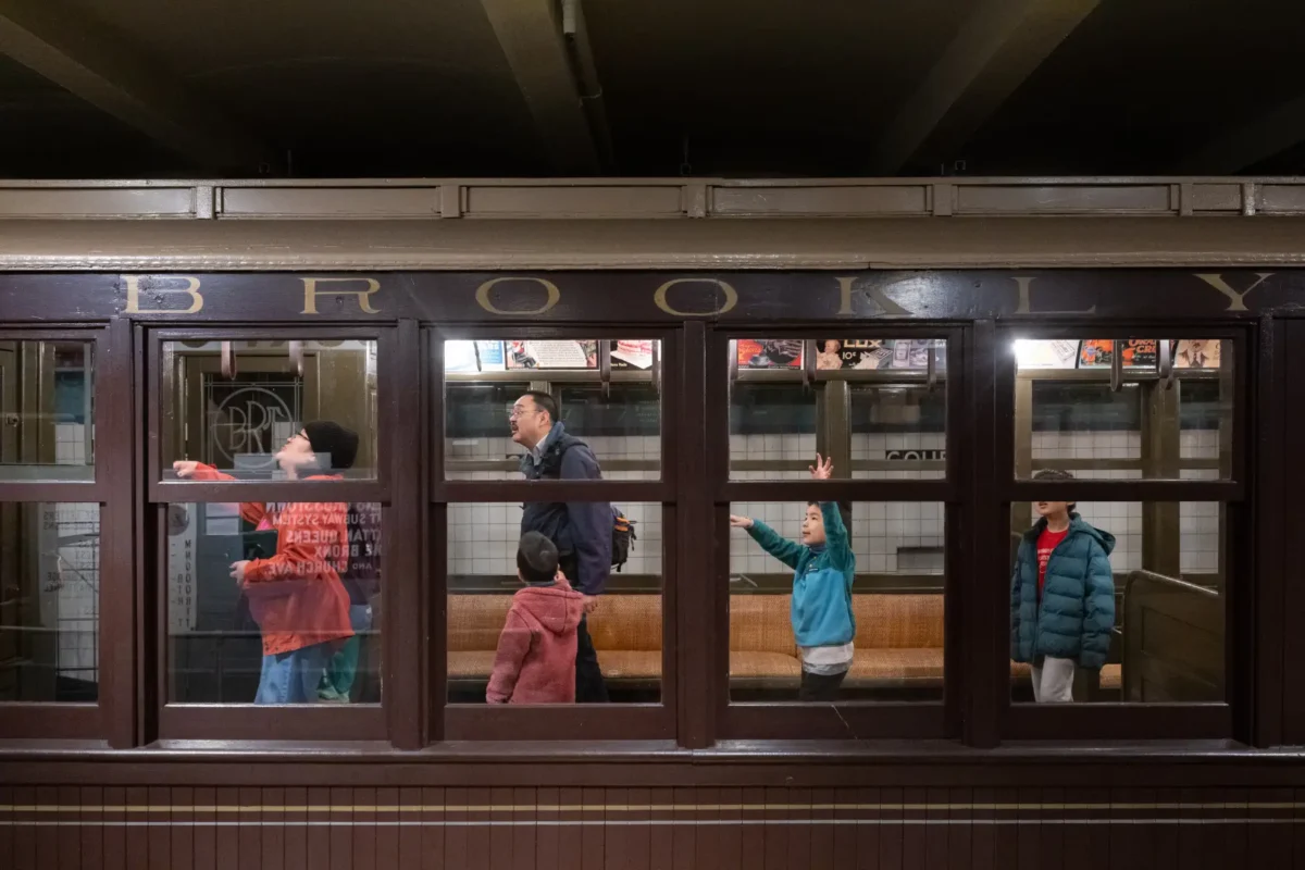 Children laugh, jump, and play inside a vintage Brooklyn Union train car.