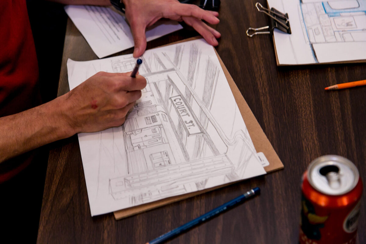 Hands sketching the platform at Court St Station.
