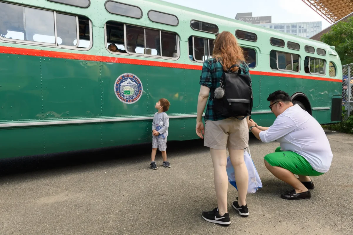 Boy standing in front of vintage bus