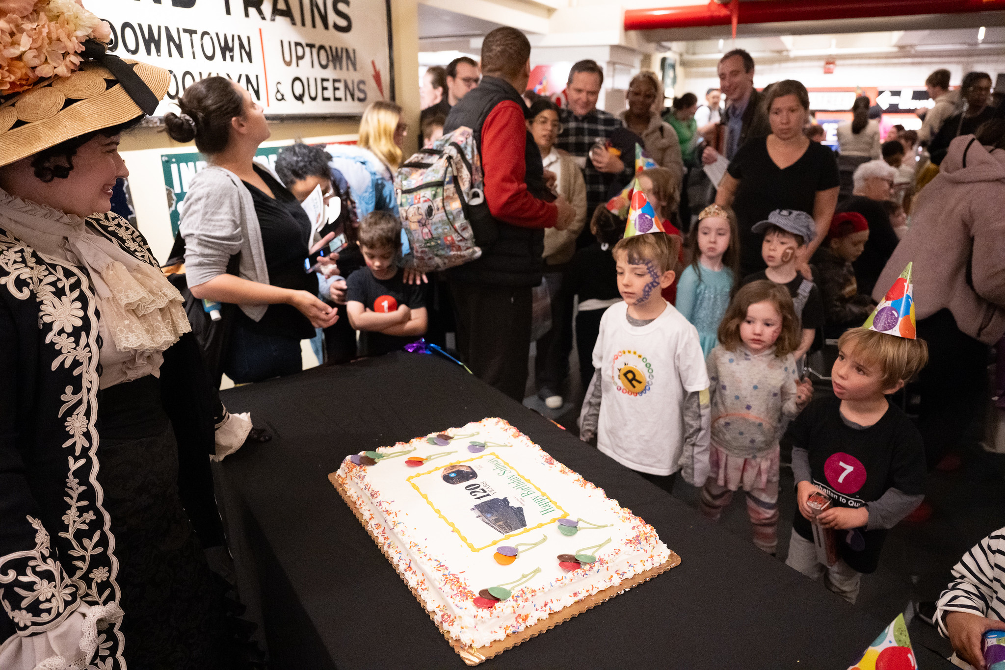 Costumed interpreter with cake and children