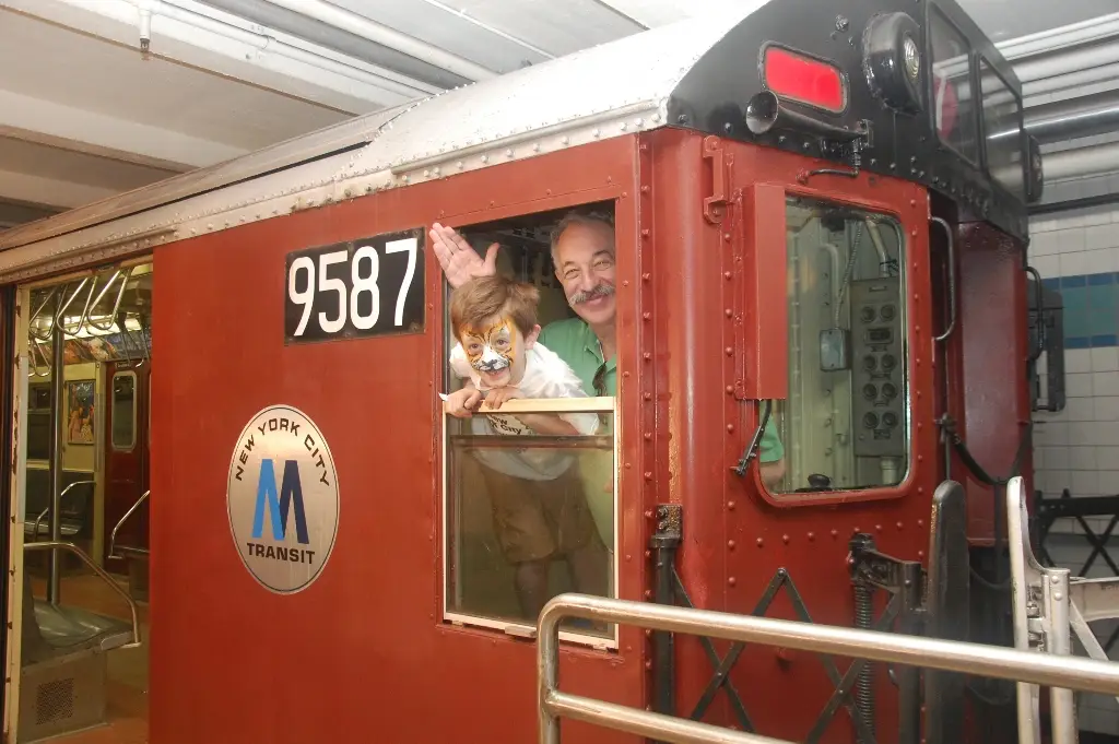 Adult and child in the conductor's cab of Redbird at Party on Wheels