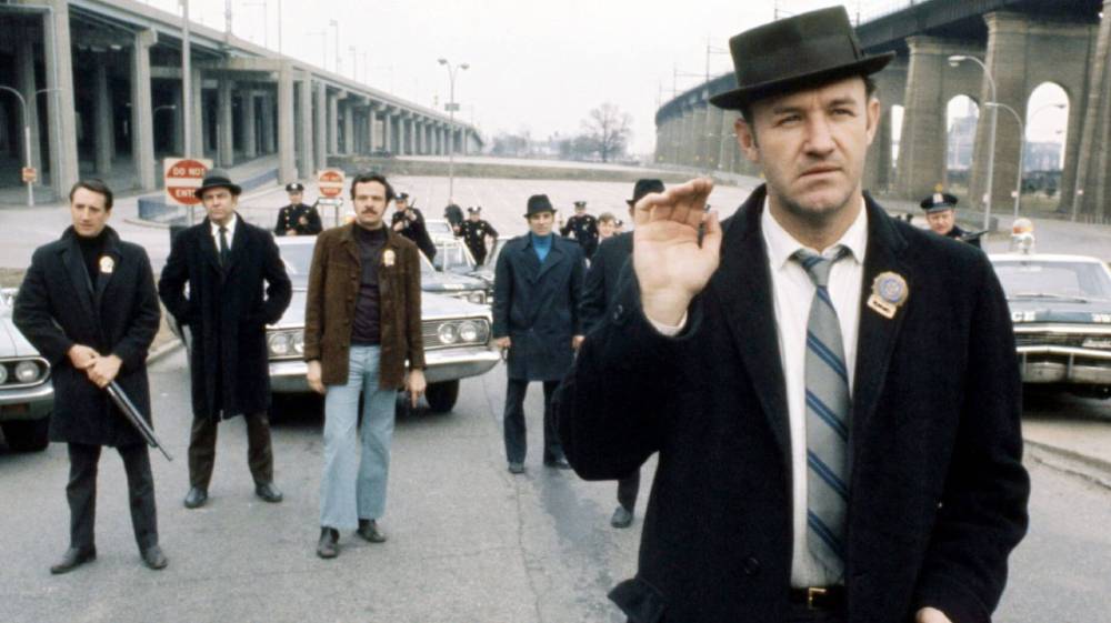 Men stand in a line in front of a car.