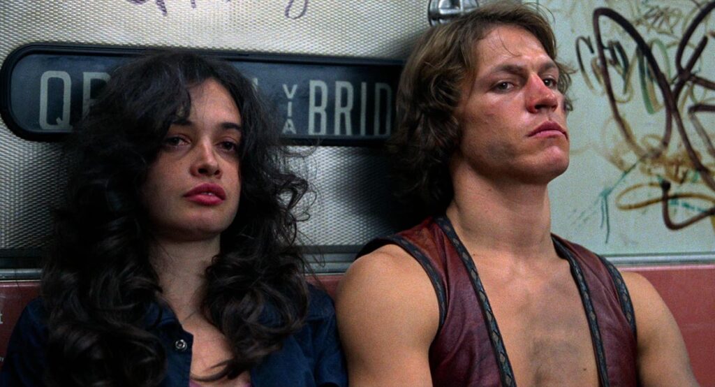A man and a woman sit next to each other on a subway.